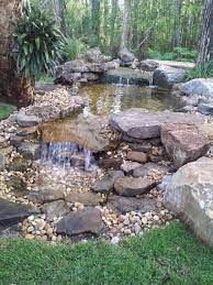 If you locate your pond right next to a fence, wall, hedge or building, you'll have to get into the water to tend that part of the pond. Diy Garden Pond Waterfall Ideas Frugal Living Waterfalls Backyard Ponds Backyard Pond Landscaping
