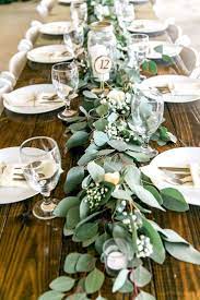 Long Feasting Table With Garland Greenery Centerpieces And Wooden Farm Tab Greenery Centerpiece Country Wedding Reception Country Wedding Decorations Reception