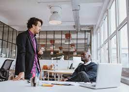 Two Young Office Workers Talking Office Photography Workplace Friendships Office Workers