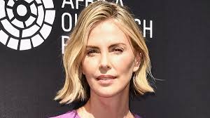 Charlize Theron is sporty chic in a white tennis skirt and sneakers as she  hosts the 20th Annual Desert Smash event in La Quinta