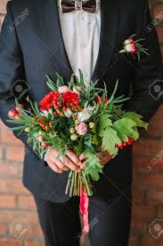 White modern wedding bouquets red. Elegant Man Dressed In A Modern Black Suit And White Shirt Holding In Hand A Wedding