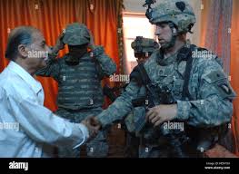 Staff Sgt. Ramon Baca shakes hand with an Iraqi man at his home in  northwest Baghdad following their conversation April 18. Baca serves as the  platoon sergeant for 1st Platoon, Company C,