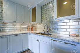 Contrasting your backsplash with your countertops might be the solution. Modern White Kitchen Design With Silver Backsplash White Shaker Stock Photo Picture And Royalty Free Image Image 93392734