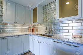 While modern spaces often cry out for a splash of colour. Modern White Kitchen Design With Silver Backsplash White Shaker Stock Photo Picture And Royalty Free Image Image 93392734