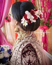 What A Beautiful Large Low Bun With Real Flower Gajra Care However Should Be Taken Before Adopting Such Hairstyles A Bridal Hair Buns Bridal Hair Bridal Updo