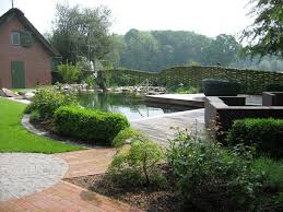 Romantischer Schwimmteich Mit Wasserspiel Angrenzender Holzterrasse Lounge Ladt Zum Entspannen Im Grunen Ein Garten Garten Landschaftsbau Gartenteich