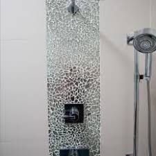 Tile shower wall with aqua accents and tan tiled flooring and adjacent walls. Shower With Large Showerhead Broken Tile Accent And Handheld Nozzle Shower Tile Shower Tile Designs Mosaic Shower