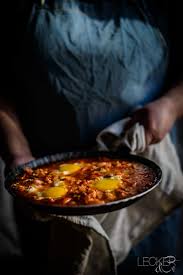 Shakshuka Ist Eine Spezialitat Der Israelischen Kuche Und Wird Aus Pochierten Eiern In Einer Tomatensauce Mit Reich Rezepte Shakshuka Rezept Lebensmittel Essen