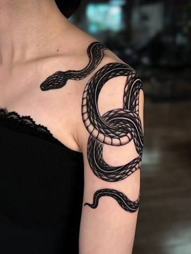 This black and grey snake tattoo by @vic.ink_ 🌹is sharply executed with precise, well-defined scales and smooth shading that adds depth🐍Its dynamic coiled movement flows naturally with the arm's shape, making the