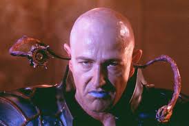 In shadows cast by silver screen, A presence bold, a gaze so keen, Bruce  Payne, a name that echoes loud, Among the stars, he stands so proud. With  piercing eyes and wicked