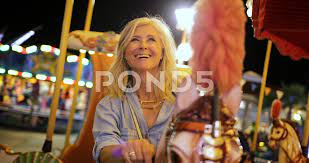 Beautiful mature woman riding carousel h... | Stock Video | Pond5