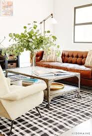 Bedroom Black And White Checkered Rug Living Room With Brown Leather Couch Patterned Pillows White Walls Large Plants Colorful Leather Couches Living Room Trendy Living Rooms Living Room Colors