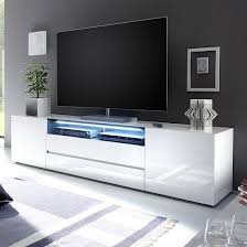 Some of the amazing features of this product: Genie Wide Lcd Tv Stand In White High Gloss With 2 Doors And 2 Drawers Also One Black Glass Fronts Lid And Led Tv Stand Decor Tv Stand Designs White Tv Stands