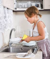 cute little girl washing dishes in the