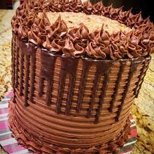 Three layers of moist chocolate cake that are stacked, one on top of another, with a so what is the history of the german chocolate cake? German Chocolate Drip Cake By Kim S Sweet Karma German Chocolate Cake Yummy Cakes Drip Cakes