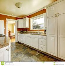 orange kitchen room with white cabinets
