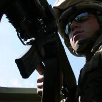 SGT. Clarence Hopkins, chief scout for the Light Armored Reconnaissance  platoon, , radios in help for wounded comrade during a Tactical Recovery of  Aircraft and Personnel course held aboard Camp Lejeune, N.C.,