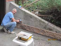 Great Way To Cover Up This Unsitely Cement Wall And Recycle The Extra Cushion Bricks That Came With The Pa Cement Wall Diy Retaining Wall Garden Retaining Wall