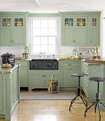 It includes stainless steel appliances and a brick fireplace fixed against the beige wall. Green Cupboards In Shabby Chic Kitchen Home Kitchens Green Kitchen Cabinets Kitchen Remodel