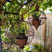 Start by placing your empty hanging basket on a bucket so it is held firmly in place whilst you add the plants. Antique Style Metal Wire Hanging Orb Planter Cages Set Of 2 Hanging Basket Garden Garden Spheres Planters