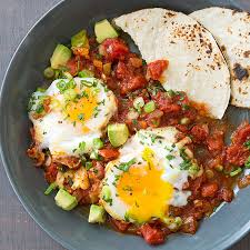 First you make the salsa by pureeing muir glen's fire roasted petite cut tomatoes with a 1/4 onion, a serrano chile, some oregano and chili powder in a blender or food processor. Huevos Rancheros Cook S Country