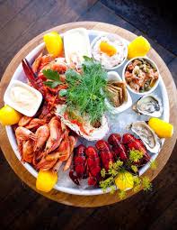 Seafood platter with shrimp, crab legs, lobster claws, oysters, lemon wedges for garnish and cocktail sauce. T L S Definitive Guide To Stockholm Seafood Platter Seafood Dinner Food