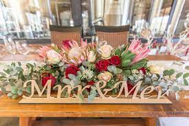 Bride And Groom Table Flower Arrangement With Proteas And Roses Table Flower Arrangements Protea Wedding Brides Table