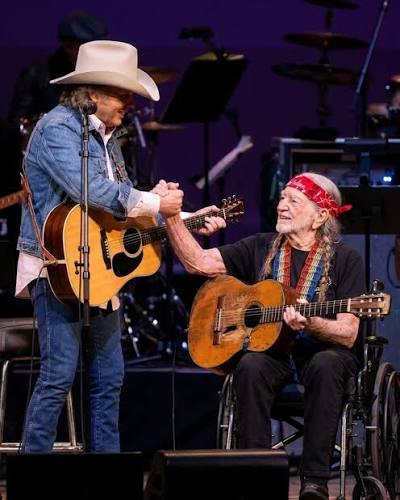 The unscripted moment between Dwight Yoakam and Willie Nelson that silenced a stadium. , No flashing lights. No autotune. Just two legends holding hands on stage., Watch as Dwight Yoakam slows down ...