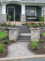 The new paver walkway is accented with a curved retaining wall and cozy freestanding wall. Front Door Curb Appeal This Paver Walkway Matches The Homes Exterior Styling El Check More At H Front Yard Walkway Front Porch Steps Front Yard Landscaping