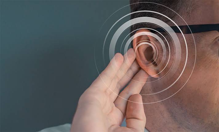 Audiologist examining patient's ear