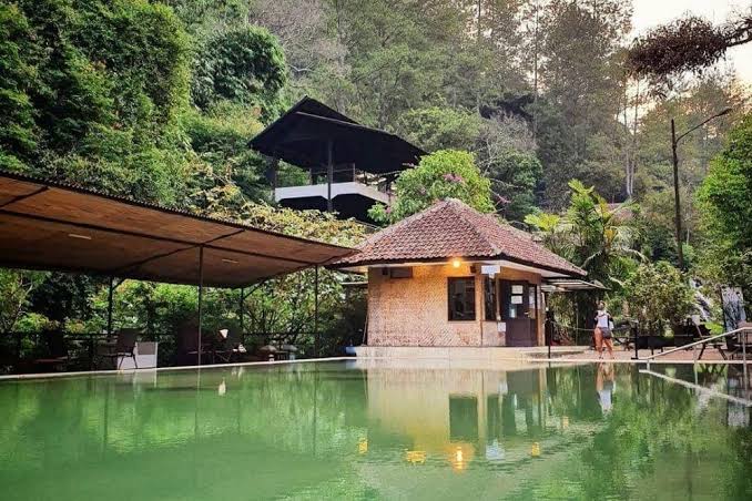 Pemandian air panas Maribaya di Lembang yang dikelilingi pepohonan hijau.