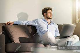 Everyone sits in the same lime green swivel chairs. Man Sitting On Couch At Home With Laptop Handsome Flat Stock Photo 263813736
