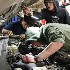 TCAT Dickson Automotive Technology students Aiden Sanders (green shirt),  Juan Perez (left) and Dawson Huggins (back) are practicing their  troubleshooting skills by testing the spark plugs and coil packs