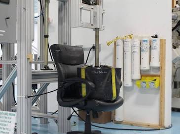 A commercial seating unit undergoing mechanical load and durability testing inside an accredited lab facility.,AI 生成