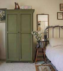 A vintage rustic bedroom with green walls, rustic furniture, green and white bedding, a shelf with frames for decor. Green Bedroom Furniture Home Decor Green Bedroom Furniture House Interior