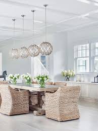 Seagrass dining chairs at a white lacquer dining table in a transitional dining room surrounded with glass sliding doors to a patio. Seagrass Dining Chairs Design Ideas