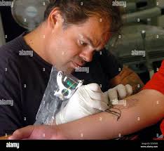 2:57PM. John Ballesteros tattoos praying hands in black ink