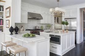 This kitchen has been two years in the making, constantly tweaking what we had (painting cabinets, painting countertops!, buying new appliances as we could afford them) until we were ready for a little bit more. Kitchen Peninsula With Statuary Marble Countertop And Cream Leather Tufted Counter Stools Tran White Kitchen Traditional Square Kitchen Square Kitchen Layout