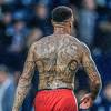 A tattoo showing what appears to be two adults and a child is seen on the back of lorenzo insigne . 3