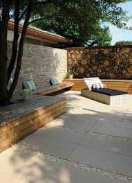 Sandfarbene Terrasse Gestaltet Mit 50 X 100 Cm Grossen Steinplatten Holzbanken Und Holzliege Der B Hinterhof Terrassen Designs Gartengestaltung Gartenfliesen