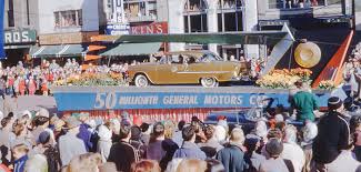 A lineup of classic American cars at a bustling outdoor car show, demonstrating the kind of vehicles at a Golden car parade.
