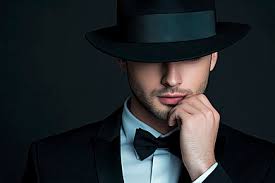 Seorang Pria Dengan Tuksedo Hitam Dan Topi Tangan Di Wajahnya Berpose  Dengan Latar Belakang Gelap, Pria, Hitam, Tuksedo Latar Belakang untuk  Unduhan Gratis