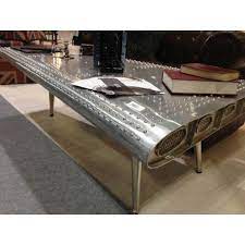 The wood frame is then covered in sheeted aluminum, and to complete the authentic aviation look finished with rivets. Industrial Aluminium Coffee Table Airplane Wing