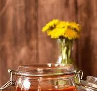 Natural honey in a transparent jar with flowers as ...