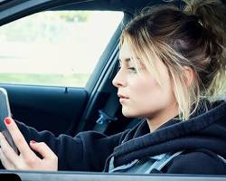 Image of person texting while driving