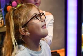 Kinley, this year's Make-A-Wish kid, plays with the claw machine and  student council members at Make-A-Wish Headquarters Colorado Jan. 30.  Student council met Kinley for the first time for an afternoon of