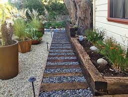 Those massive reservoirs of cancer causing chemicals don't belong in any. A Creative Use Of Railroad Ties River Rocks And Gravel Combined With Large Clay Pots And Drou Front Garden Landscape Front Garden Backyard Landscaping Designs