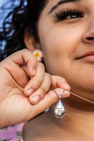 Could someone place the necklace in his hands