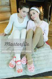 Zwei Teen Girls sitzen am Kamin, tragen Strumpfhosen und Pantoffeln, Blick  in die Kamera, in voller Länge - Stockbilder - Masterfile - Premium RF  Lizenzfrei, Bildnummer: 695-03389345