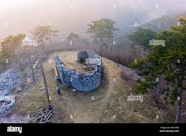 Aerial shot of boy hiking around remains of ruined church Sveta Katarina  (St Catherine), Karst, Slovenia Stock Photo